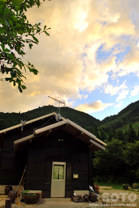黄色く染まった雲と山小屋